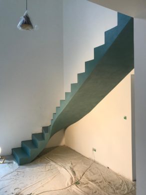 audacieux  escalier crémaillère dans une pièce à vivre en béton ciré vernis mat couleur malachite  pour un particulier