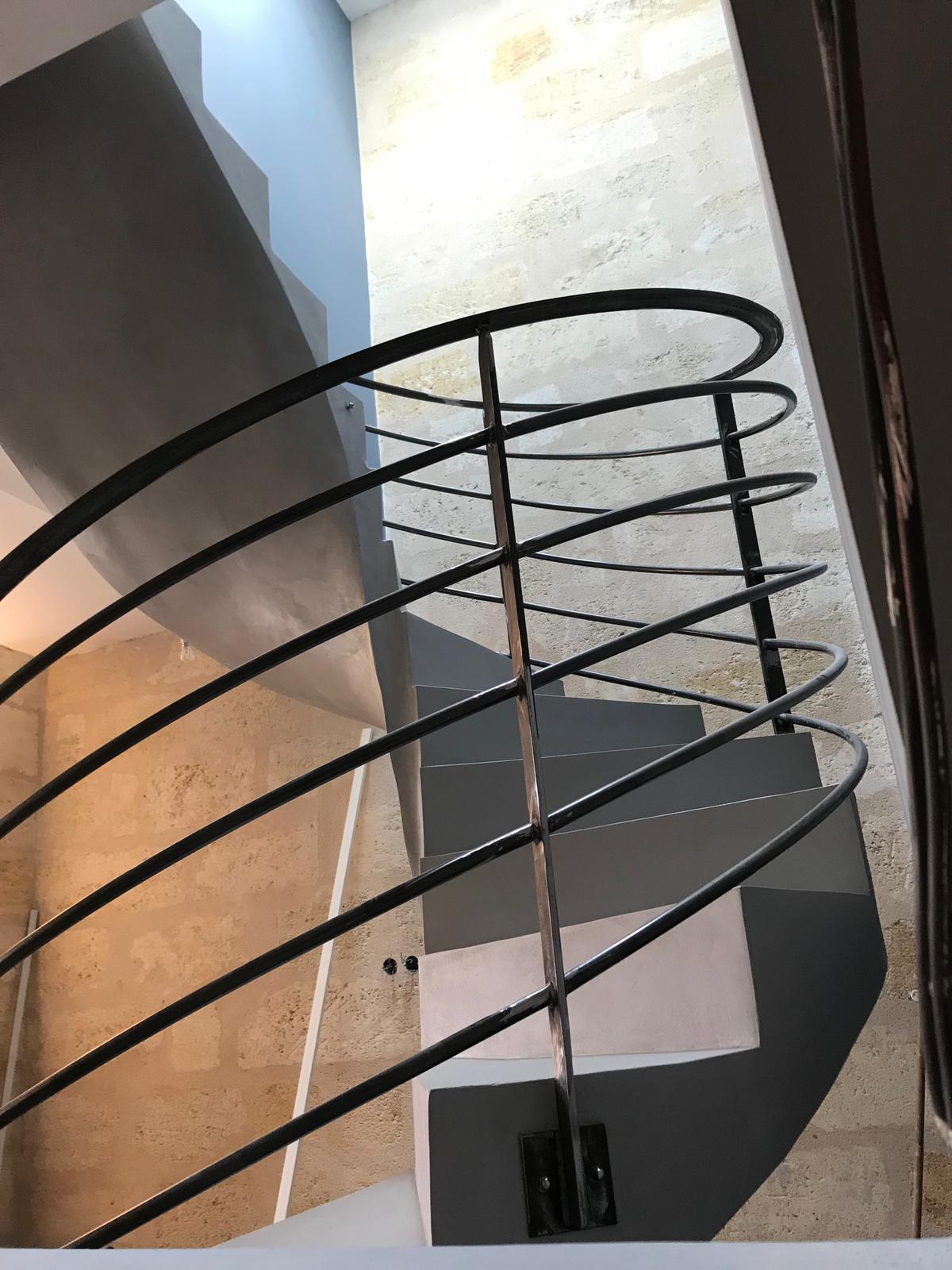 somptueux escalier à paillasse hélicoïdal en béton ciré couleur gris souris pour un architecte
