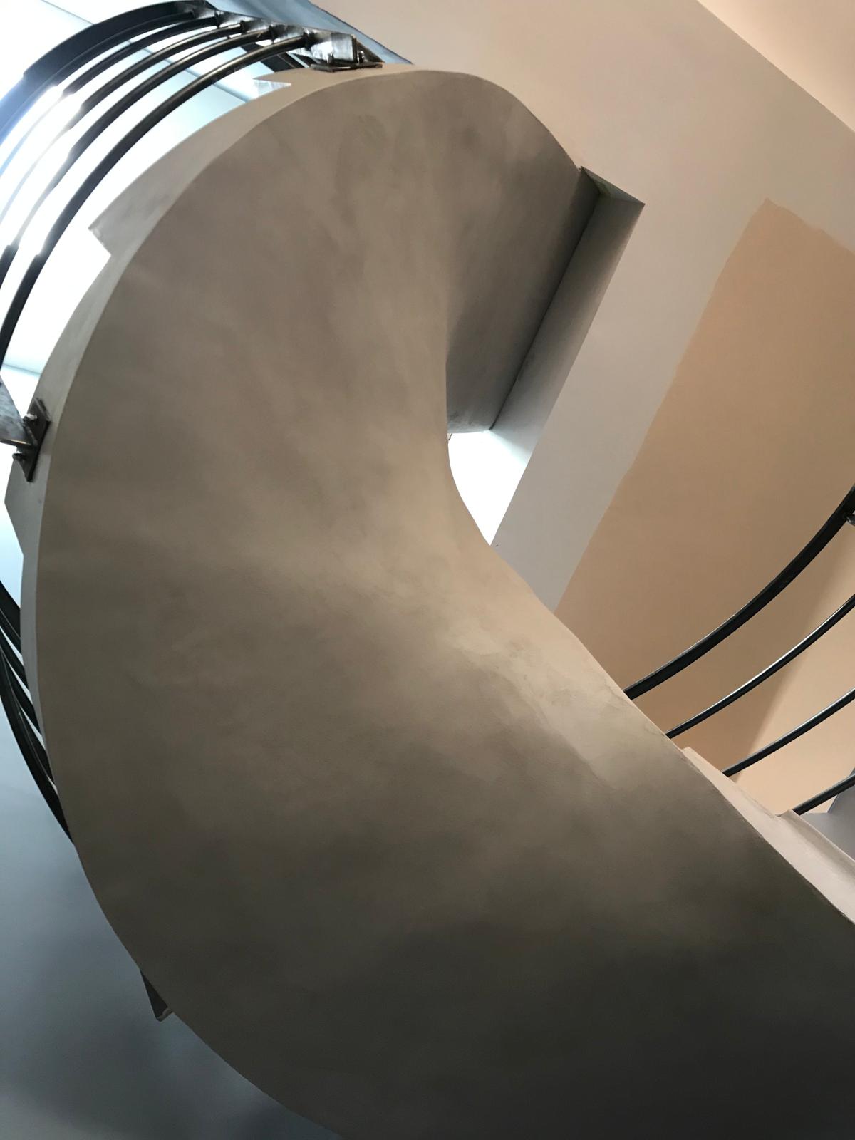 somptueux escalier à paillasse hélicoïdal en béton ciré couleur gris souris pour un architecte