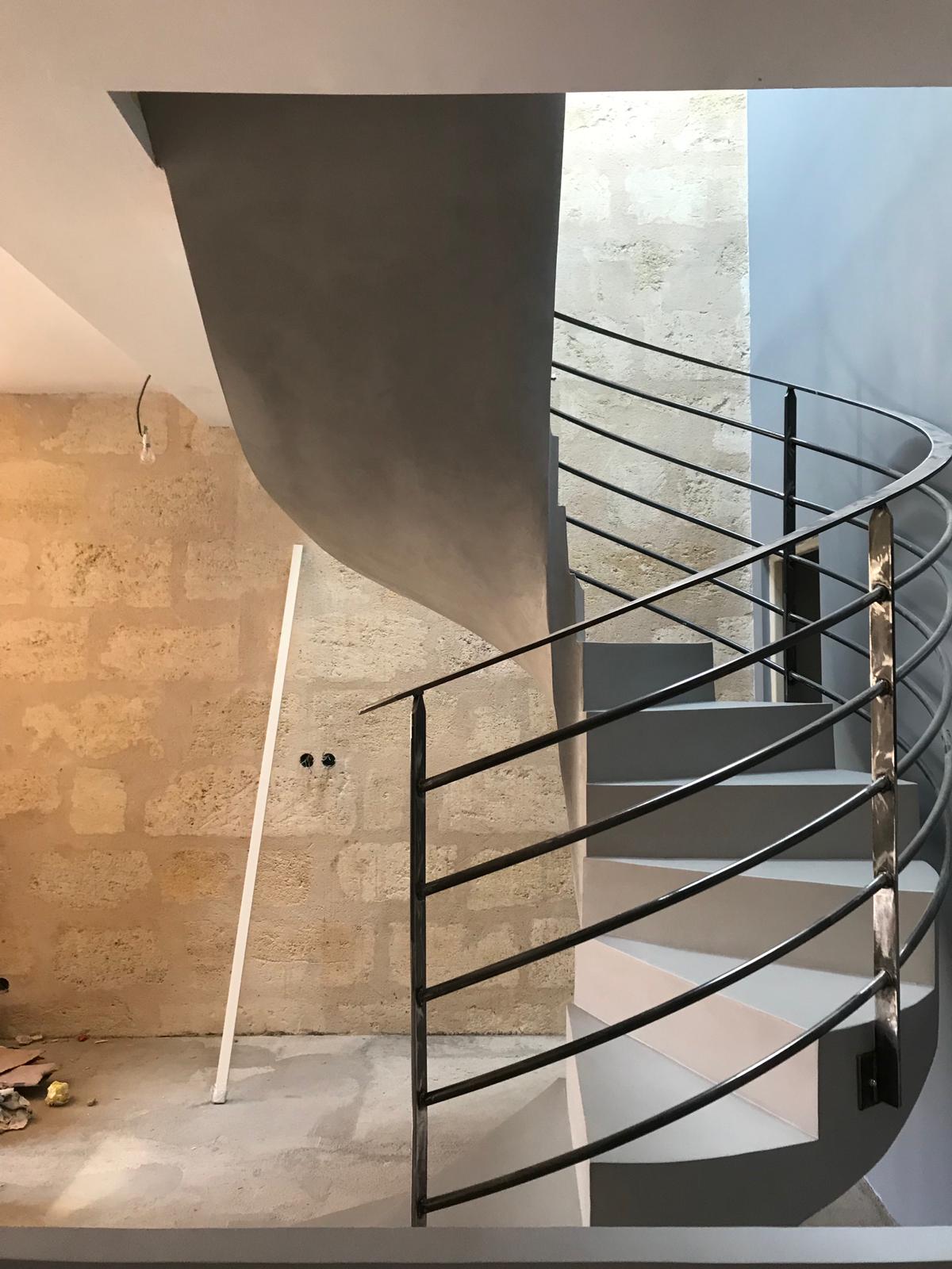 somptueux escalier à paillasse hélicoïdal en béton ciré couleur gris souris pour un architecte