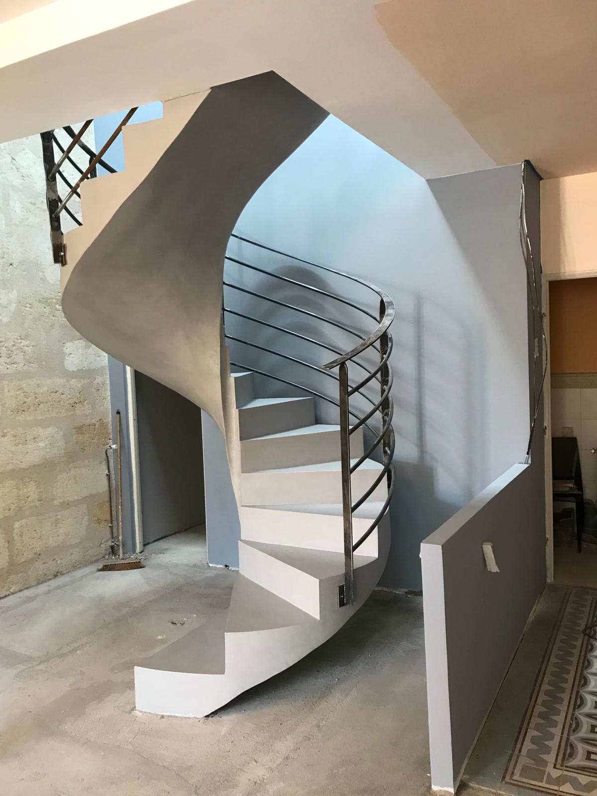 somptueux escalier à paillasse hélicoïdal en béton ciré couleur gris souris pour un architecte