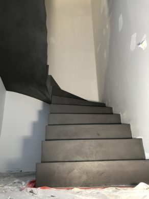 superbe escalier à paillasse deux quart tournant en béton ciré couleur gris orbital  pour un constructeur