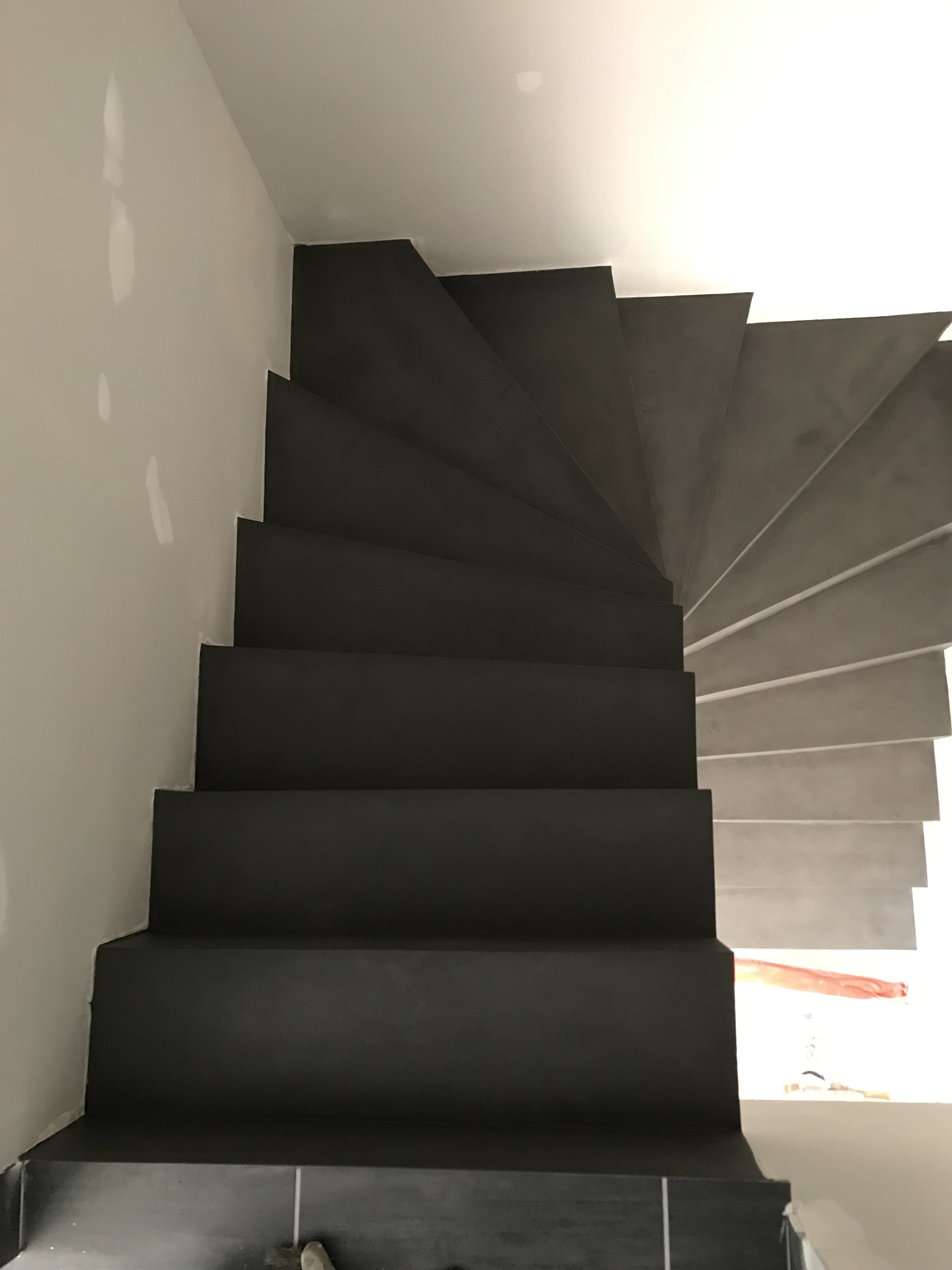 superbe escalier à paillasse deux quart tournant en béton ciré couleur gris orbital pour un constructeur