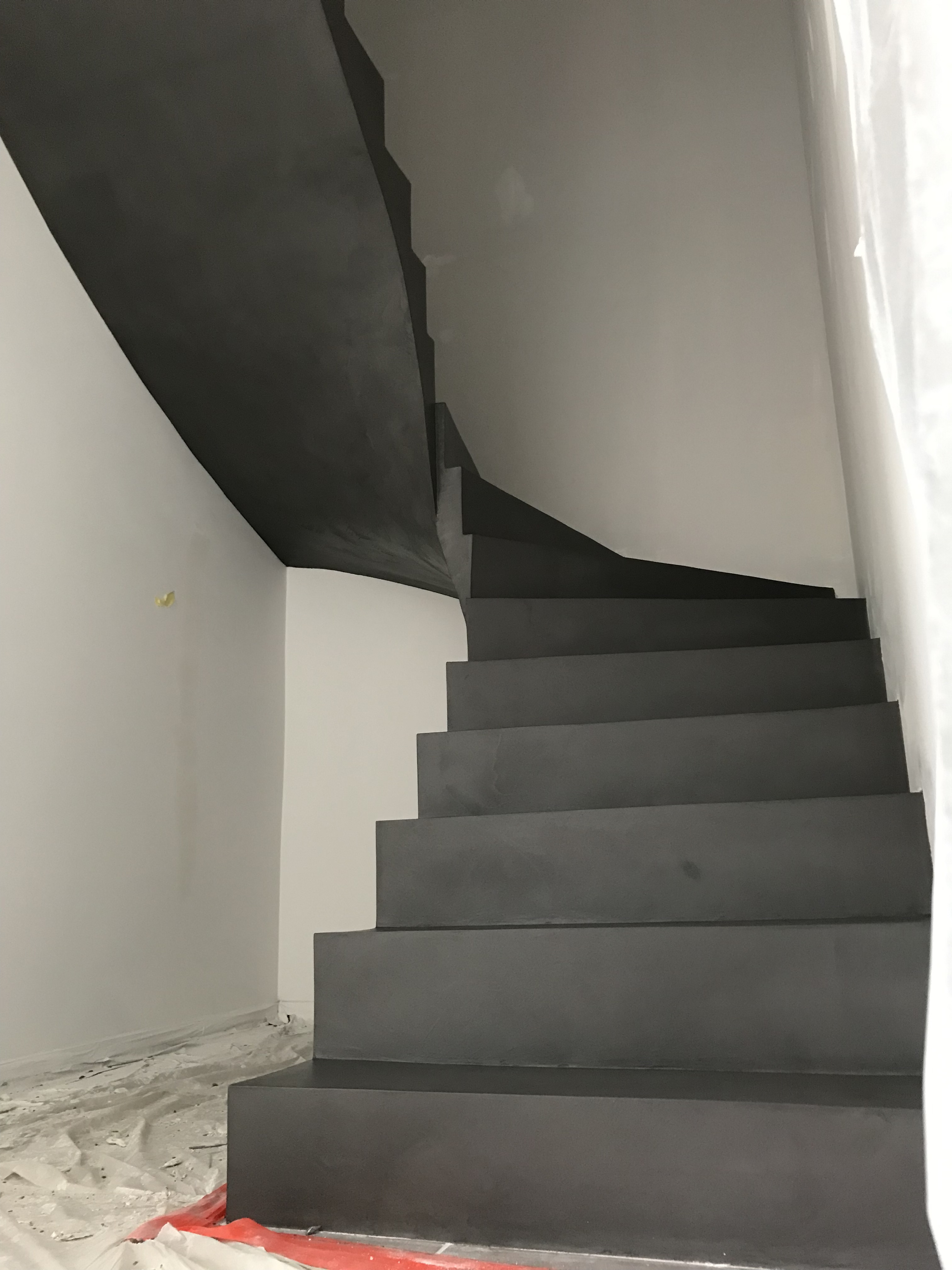 superbe escalier à paillasse deux quart tournant en béton ciré couleur gris orbital pour un constructeur