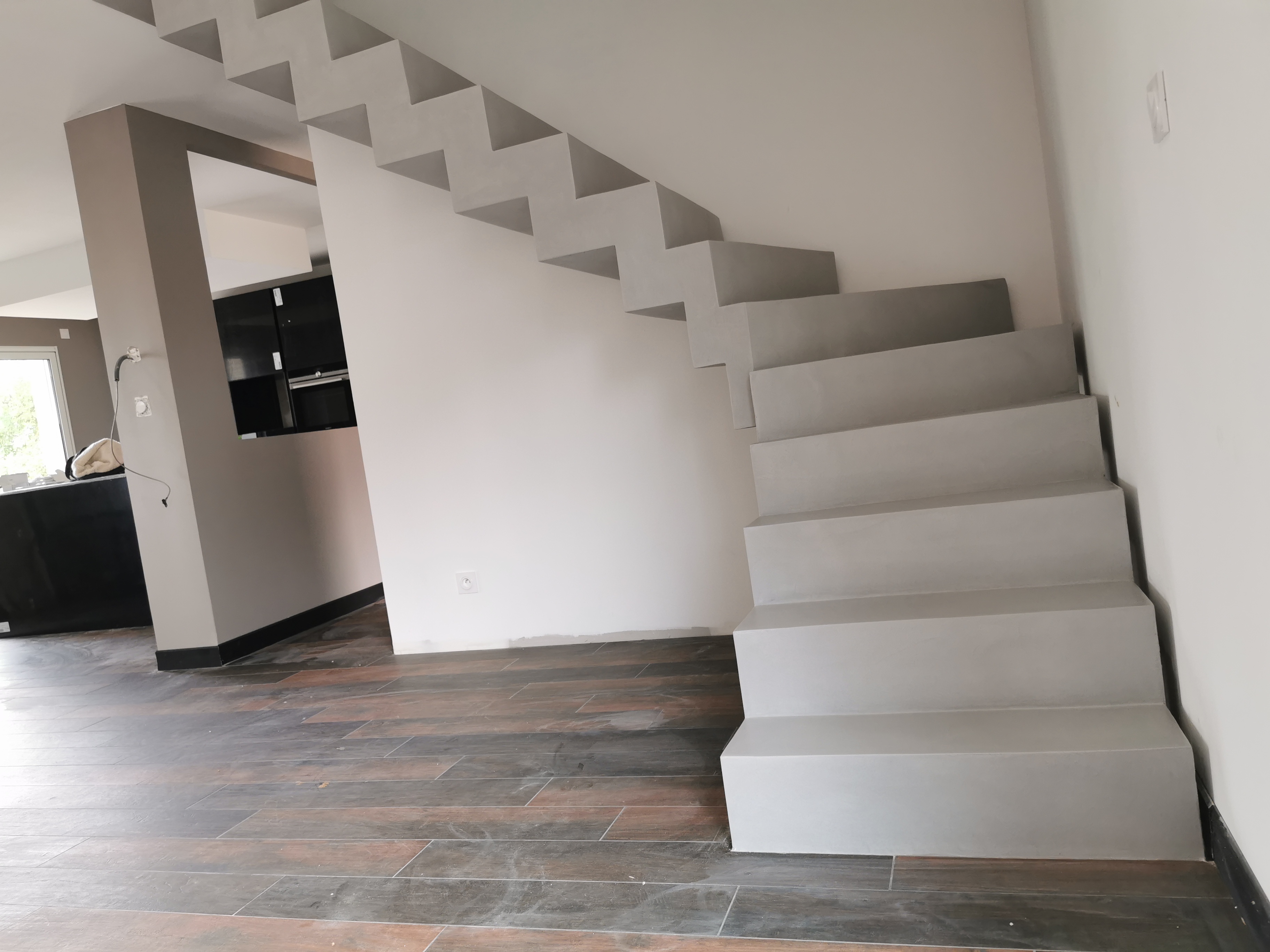 sublime escalier crémaillère décollé du mur en béton ciré vernis mat couleur gris souris À Quinsac près de bordeaux pour un constructeur