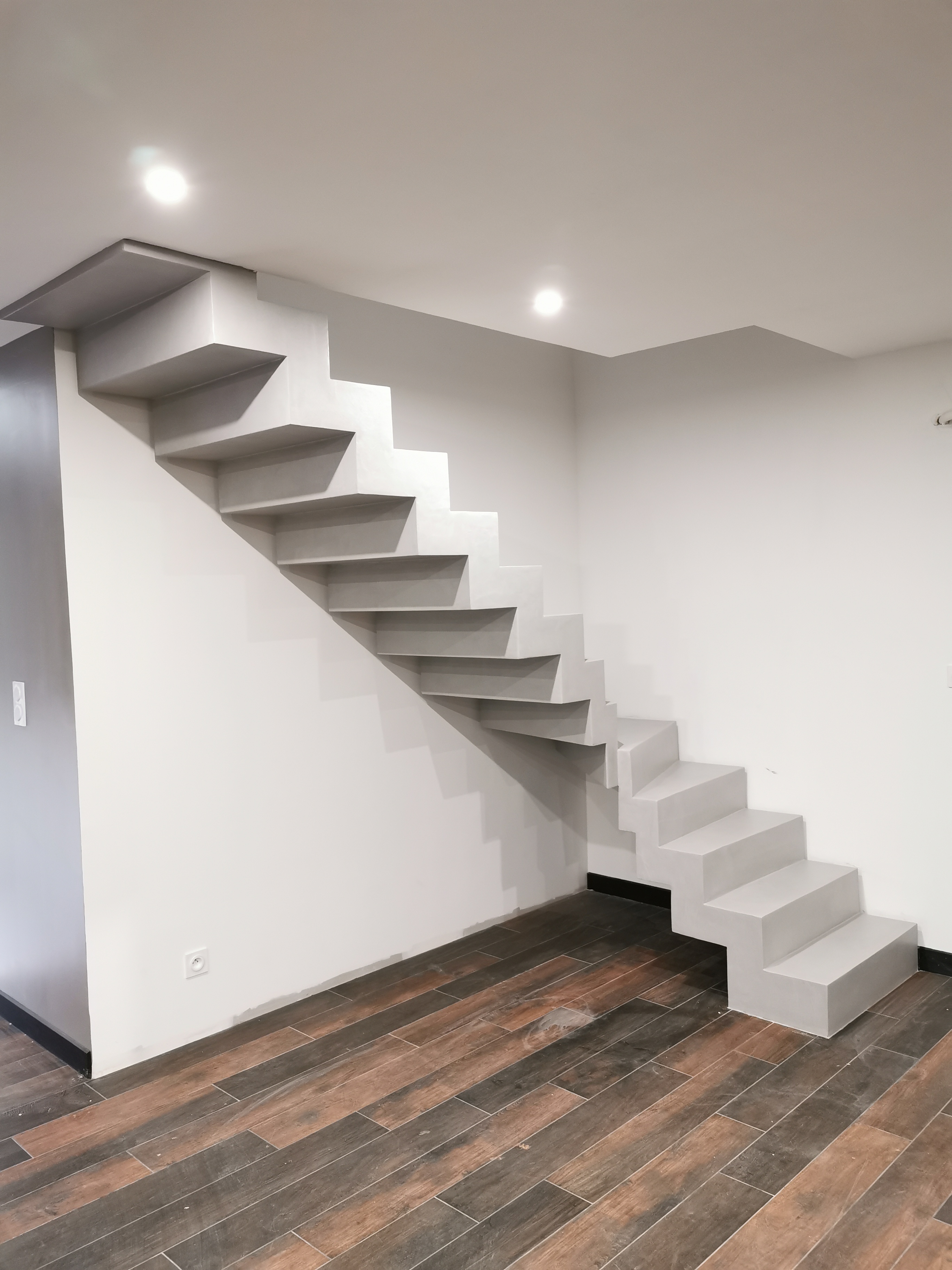 sublime escalier crémaillère décollé du mur en béton ciré vernis mat couleur gris souris À Quinsac près de bordeaux pour un constructeur