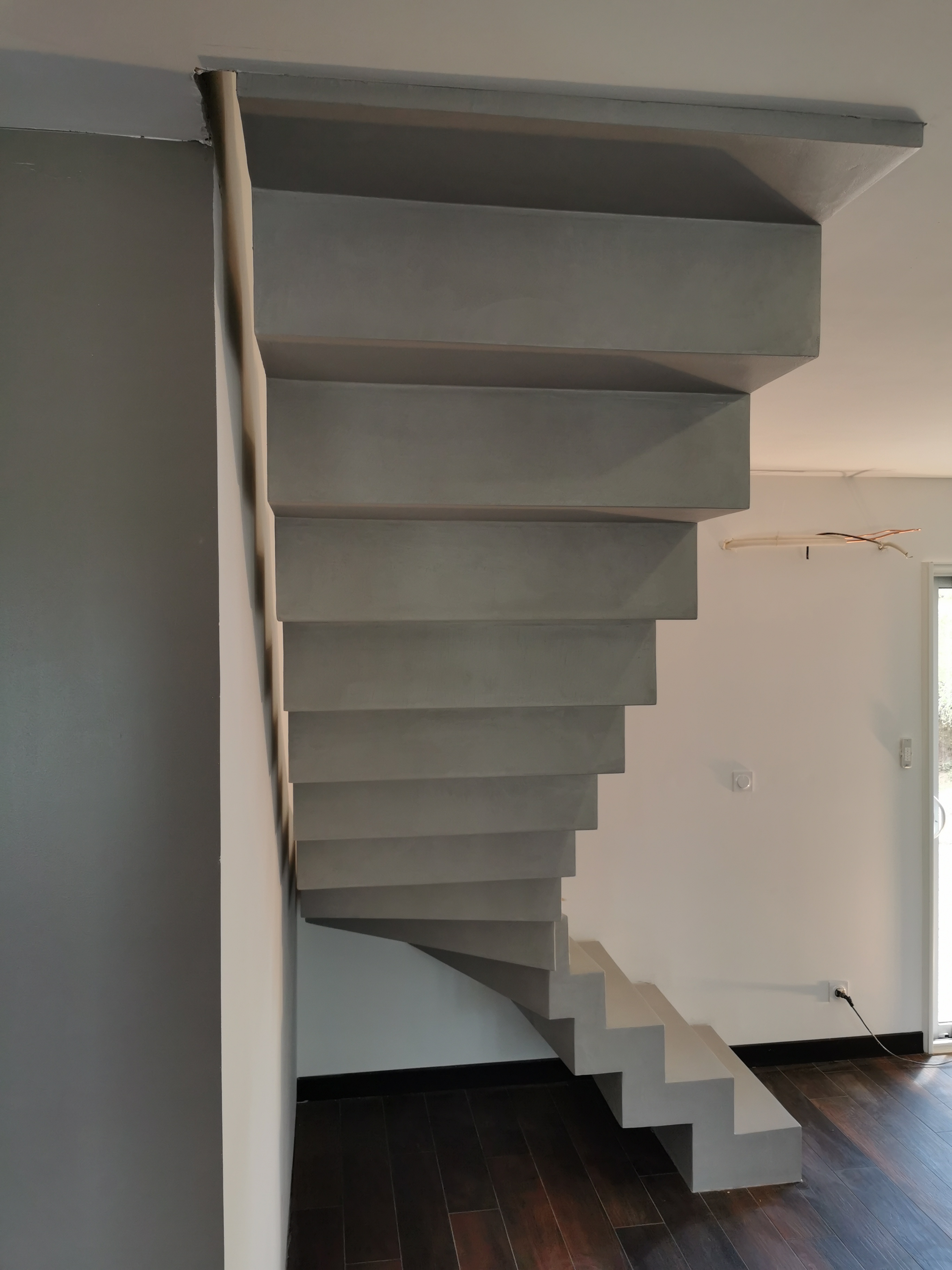 sublime escalier crémaillère décollé du mur en béton ciré vernis mat couleur gris souris À Quinsac près de bordeaux pour un constructeur