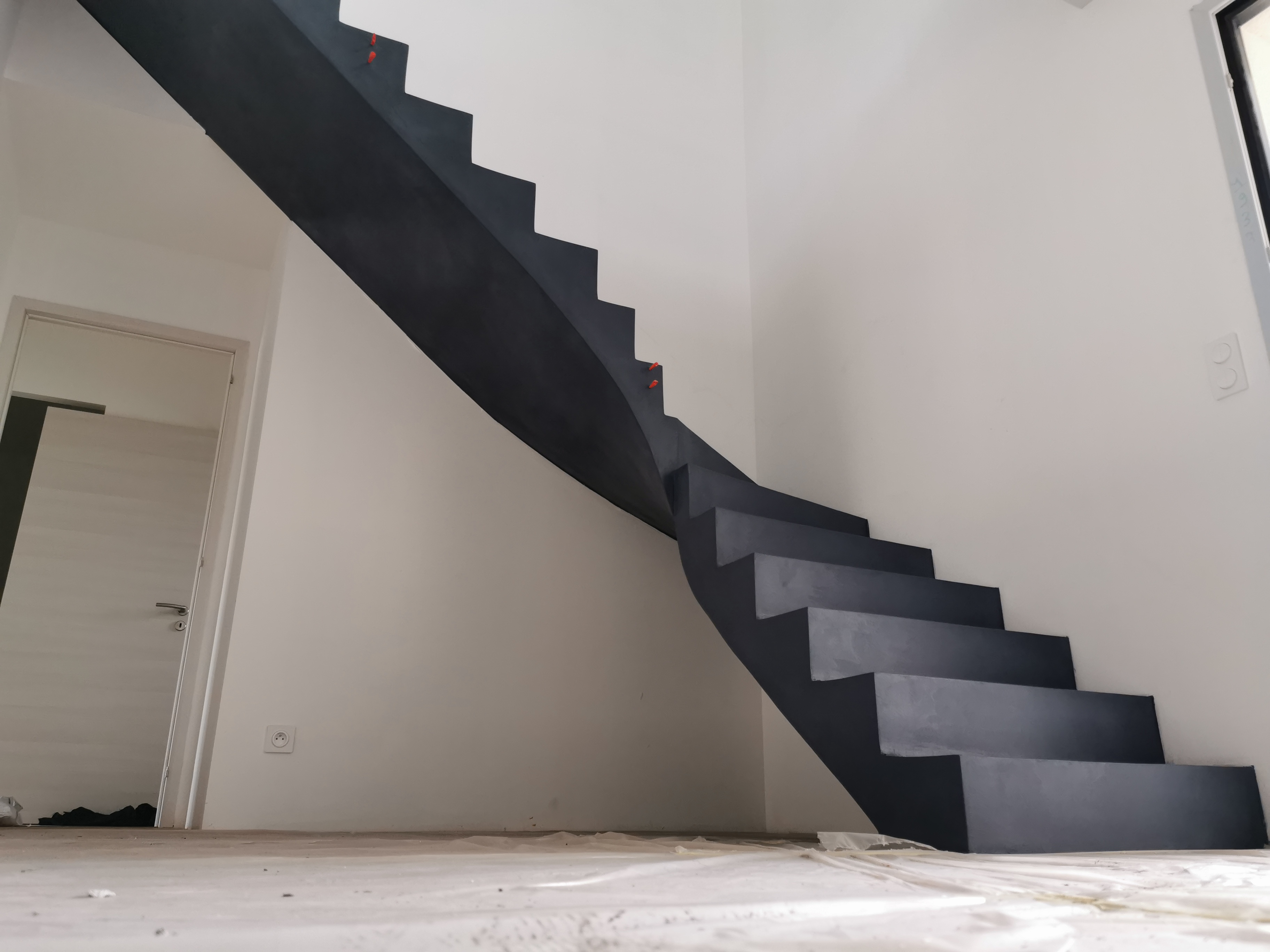 audacieux escalier à paillasse un quart tournant en béton ciré vernis mat couleur oxydium Au Taillan médoc proche de Bordeaux en Gironde pour un constructeur