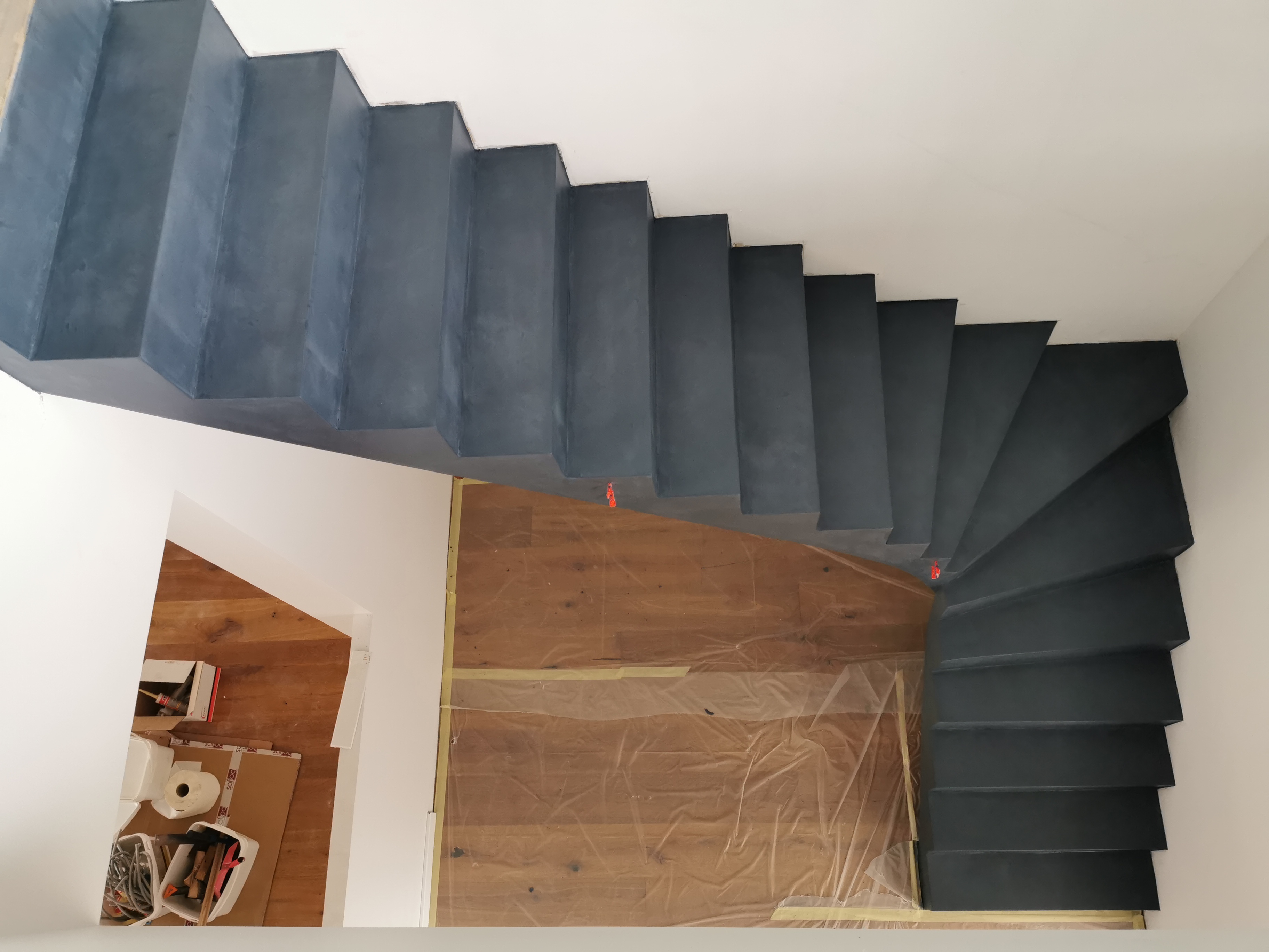 audacieux escalier à paillasse un quart tournant en béton ciré vernis mat couleur oxydium Au Taillan médoc proche de Bordeaux en Gironde pour un constructeur