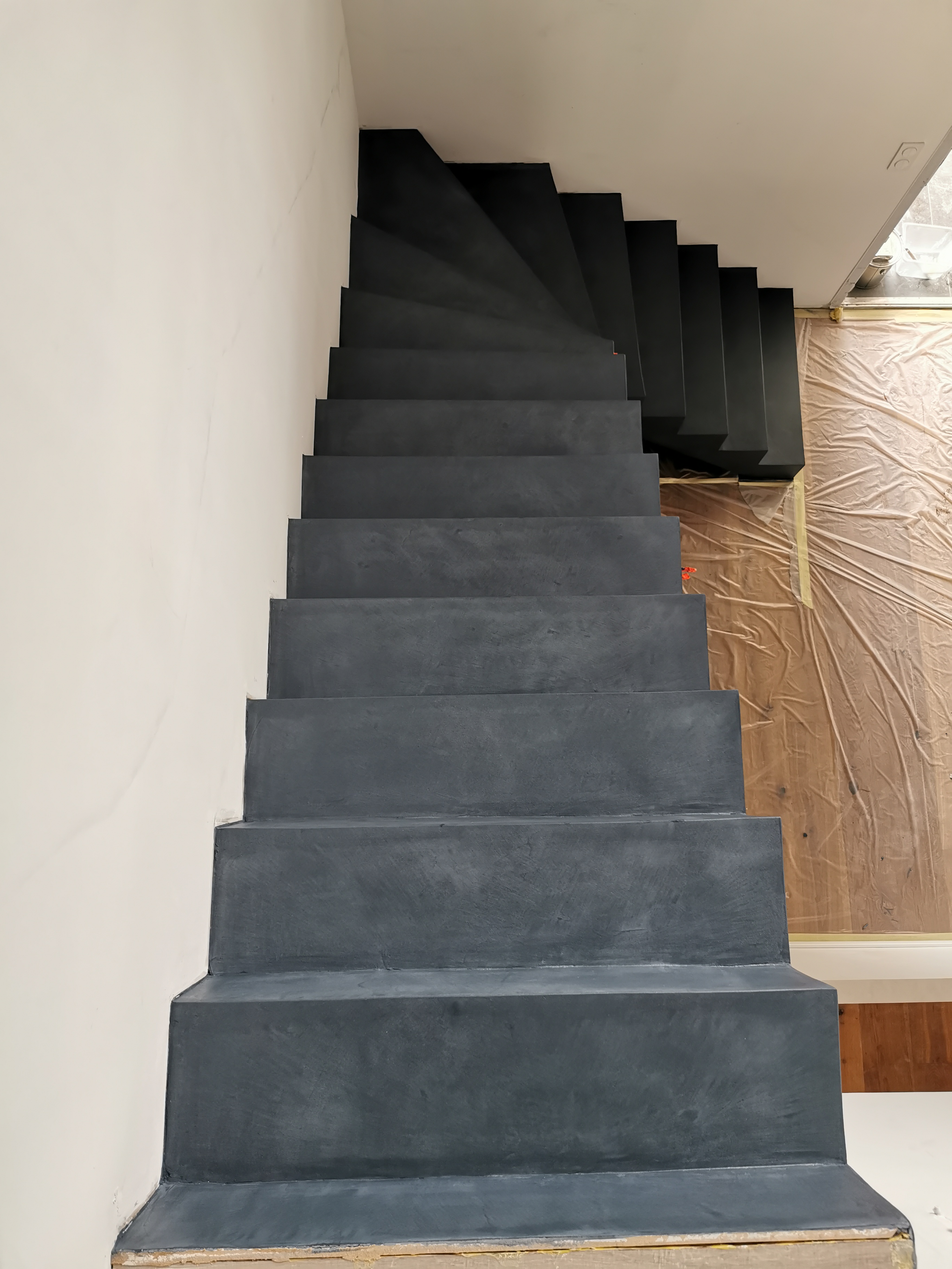 audacieux escalier à paillasse un quart tournant en béton ciré vernis mat couleur oxydium Au Taillan médoc proche de Bordeaux en Gironde pour un constructeur