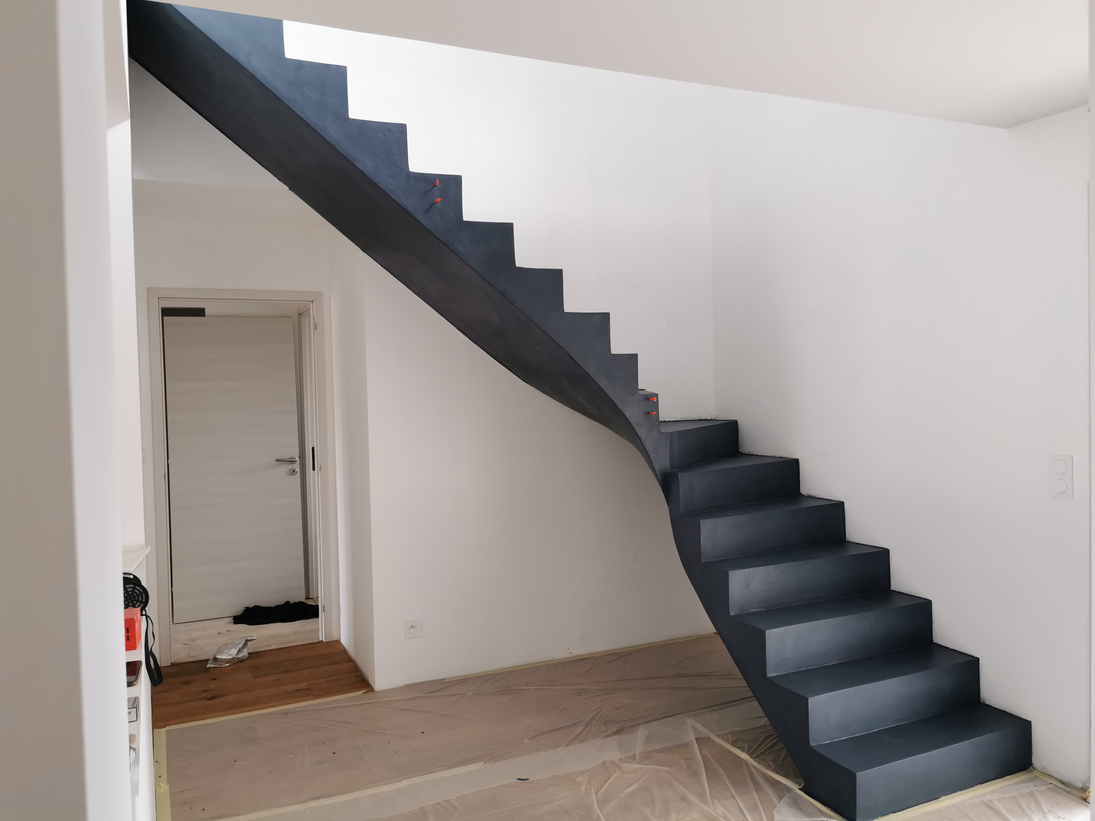audacieux escalier à paillasse un quart tournant en béton ciré vernis mat couleur oxydium Au Taillan médoc proche de Bordeaux en Gironde pour un constructeur