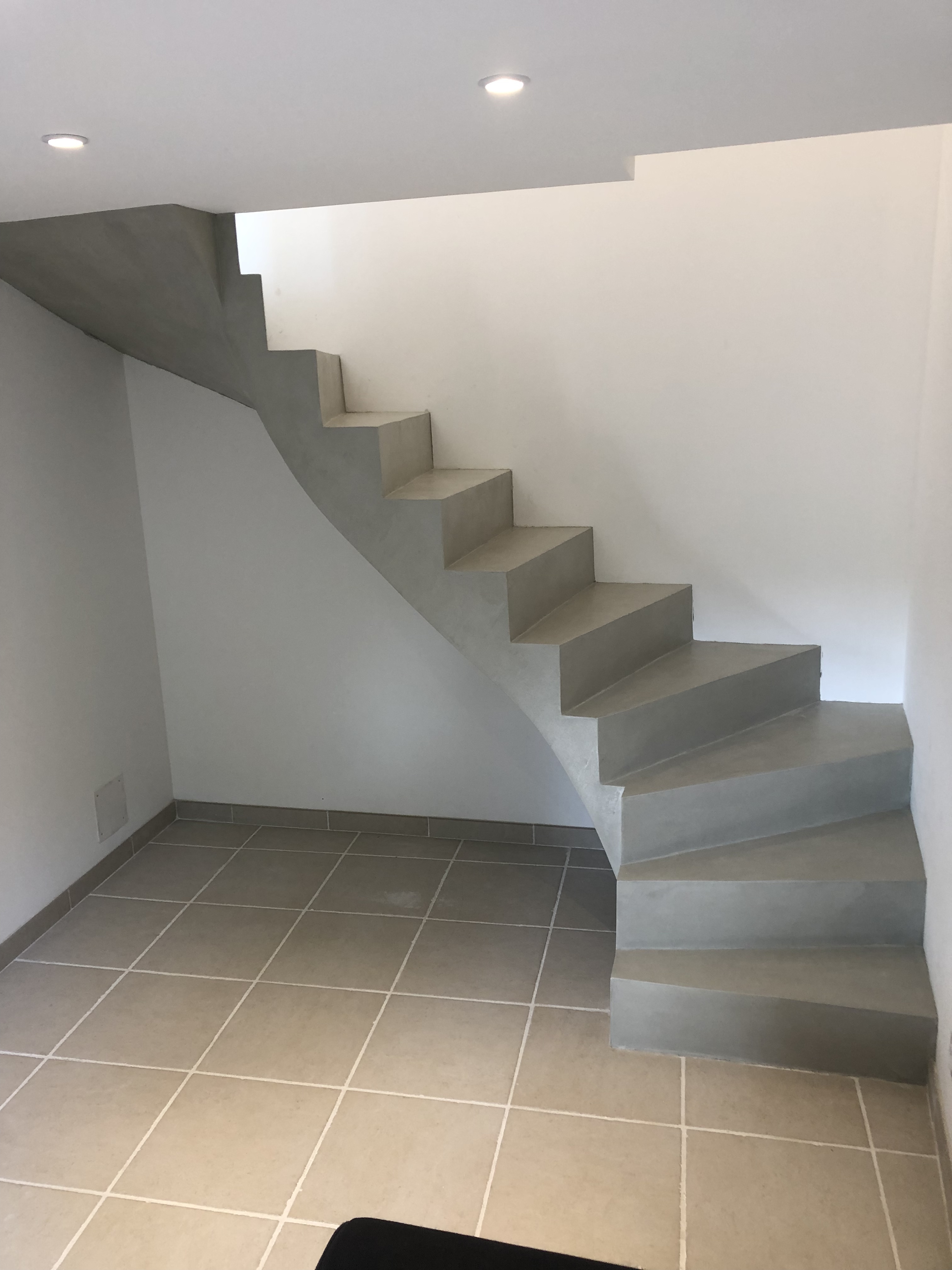 audacieux escalier à paillasse deux quart tournant en béton ciré vernis soyeux couleur gris perle à Royan en Charente maritime dans la région nouvelle aquitaine pour un particulier