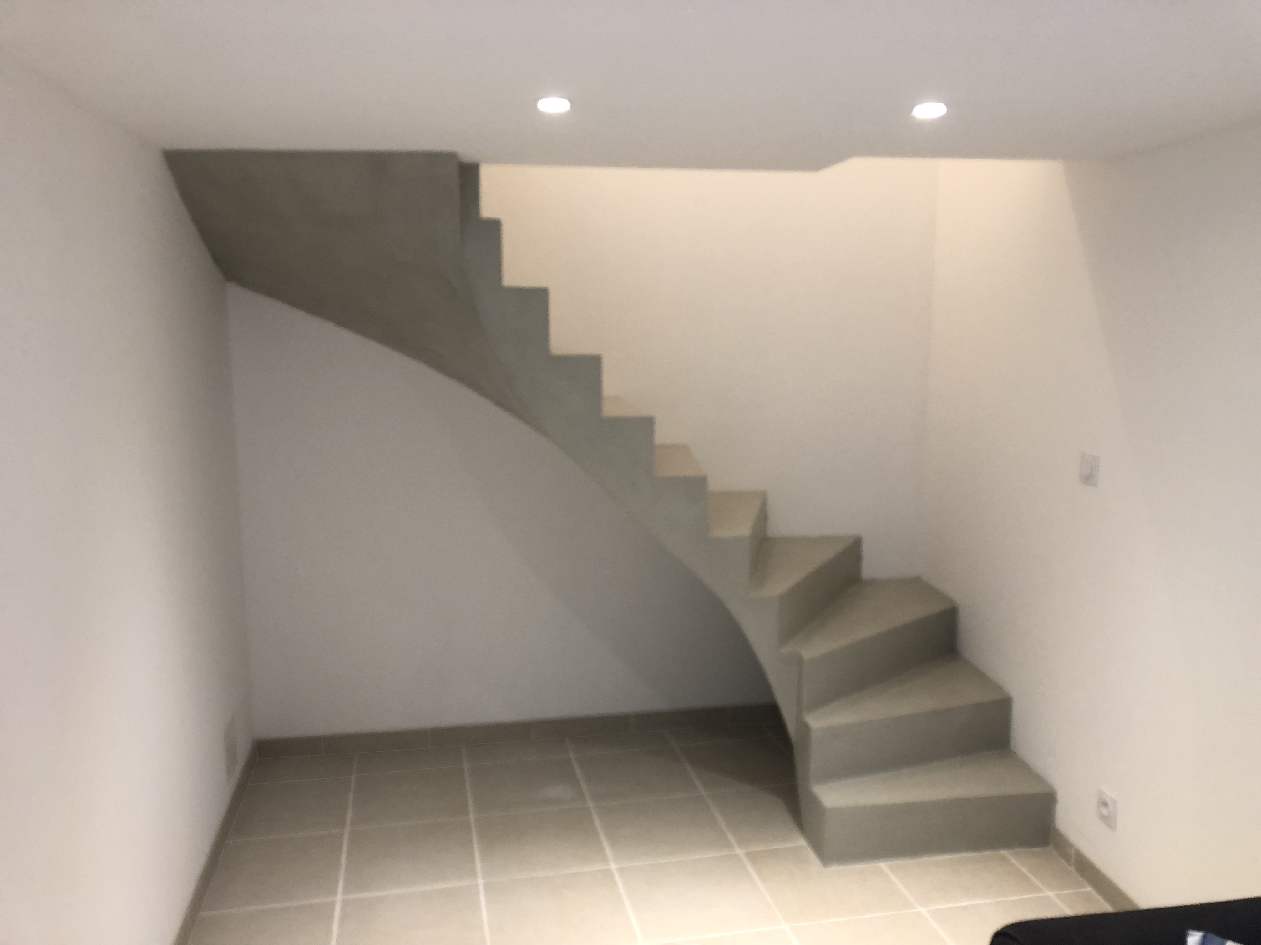 audacieux escalier à paillasse deux quart tournant en béton ciré vernis soyeux couleur gris perle à Royan en Charente maritime dans la région nouvelle aquitaine pour un particulier