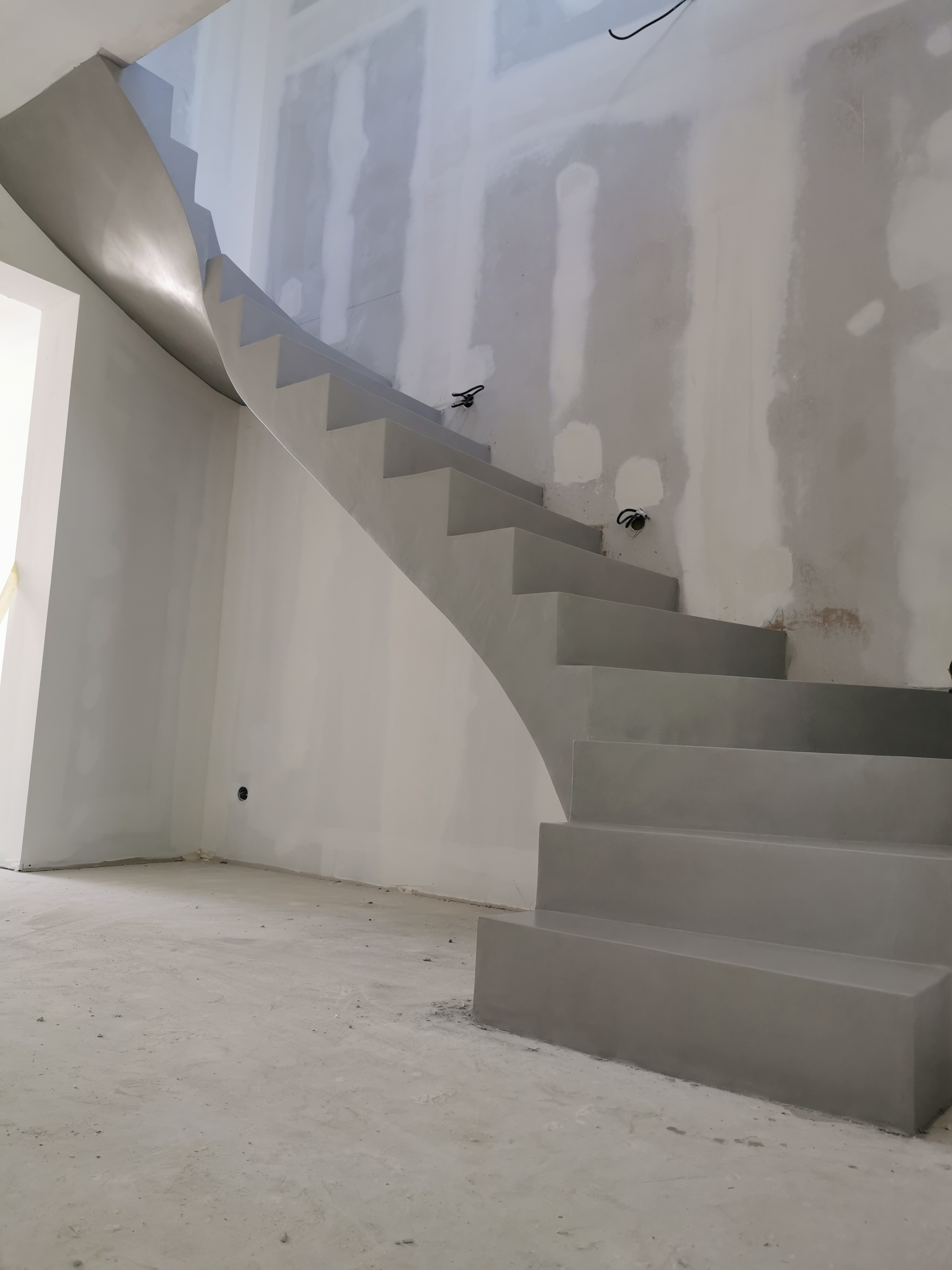 elégant escalier à paillasse deux quart tournant en béton ciré vernis mat couleur gris souris Au bouscat à Bordeaux en Aquitaine pour un maitre d'œuvre