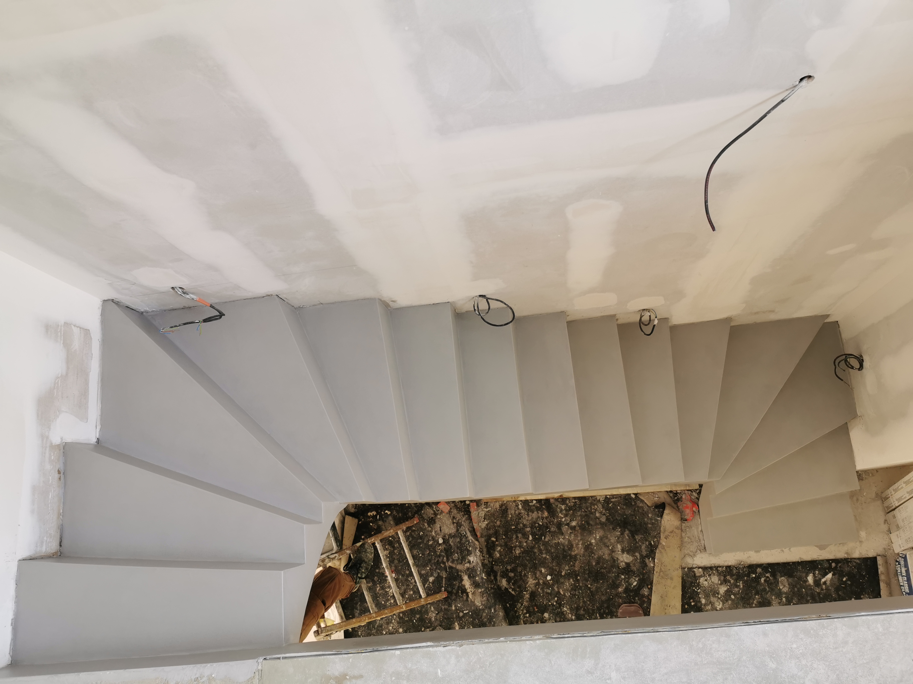 elégant escalier à paillasse deux quart tournant en béton ciré vernis mat couleur gris souris Au bouscat à Bordeaux en Aquitaine pour un maitre d'œuvre