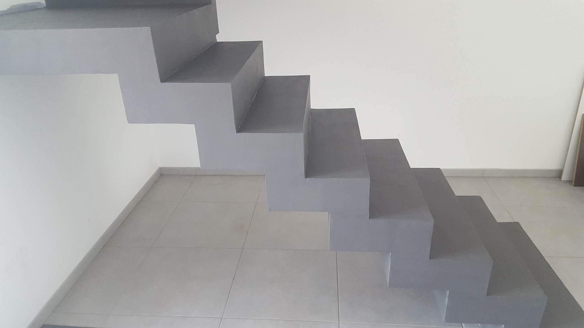 somptueux escalier crémaillère avec palier intermédiaire en béton ciré couleur gris orbital A parentis en born dans le départements de les Landes en Nouvelle Aquitaine. pour un constructeur