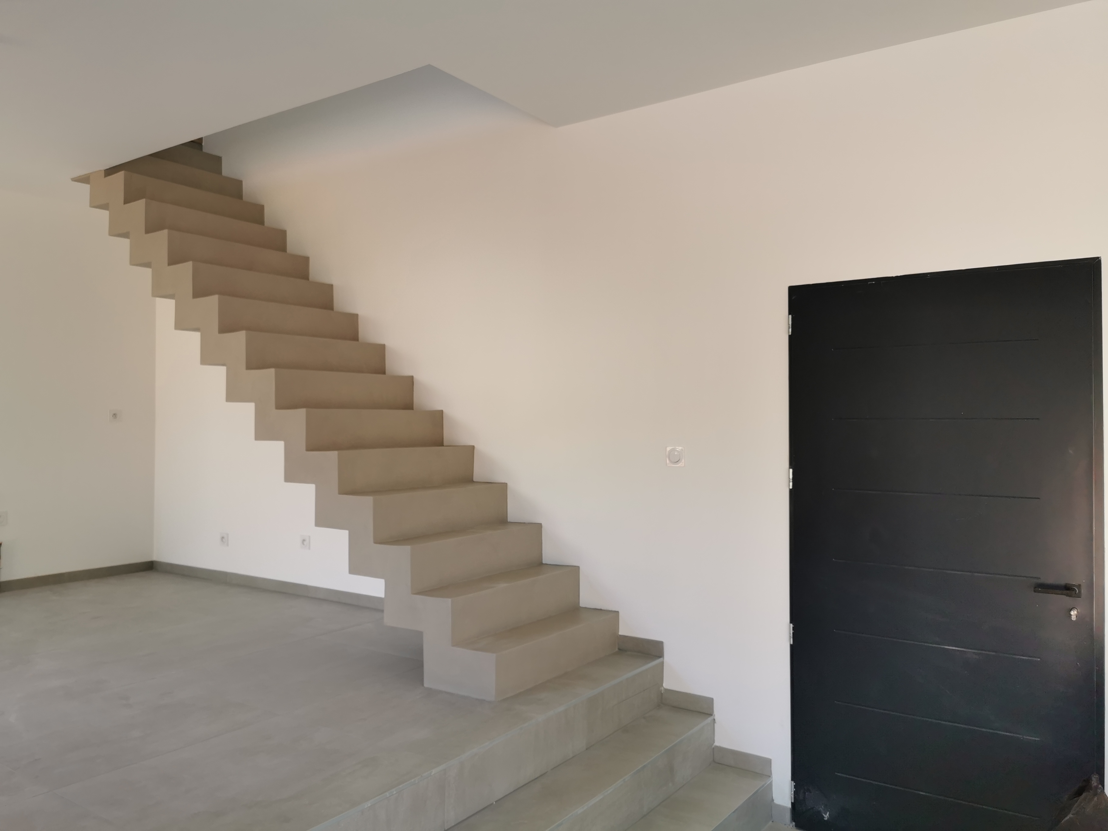 sublime escalier crémaillère dans une pièce à vivre en béton ciré vernis mat couleur galet original À arcachon proche Bordeaux pour un architecte
