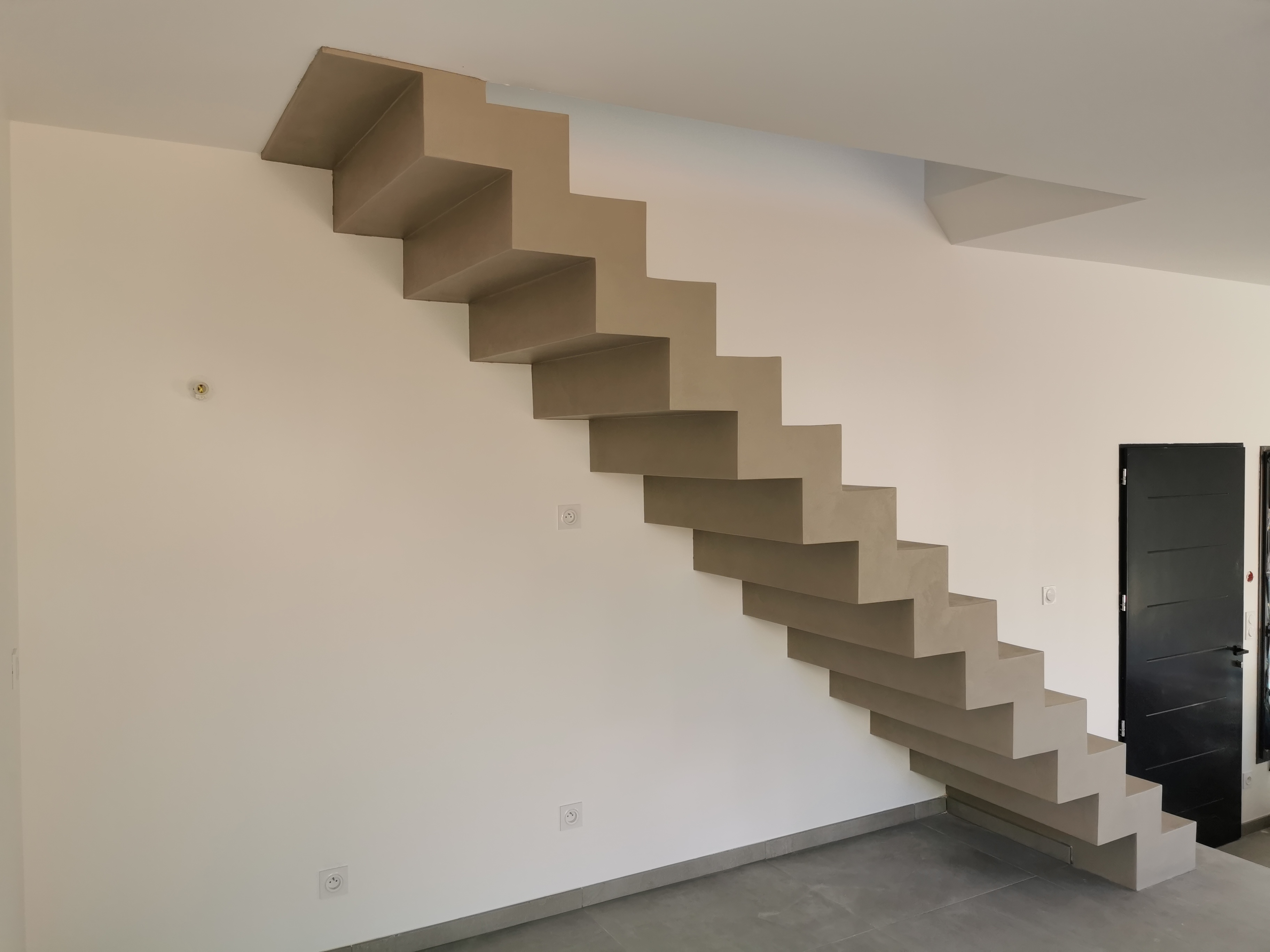 sublime escalier crémaillère dans une pièce à vivre en béton ciré vernis mat couleur galet original À arcachon proche Bordeaux pour un architecte
