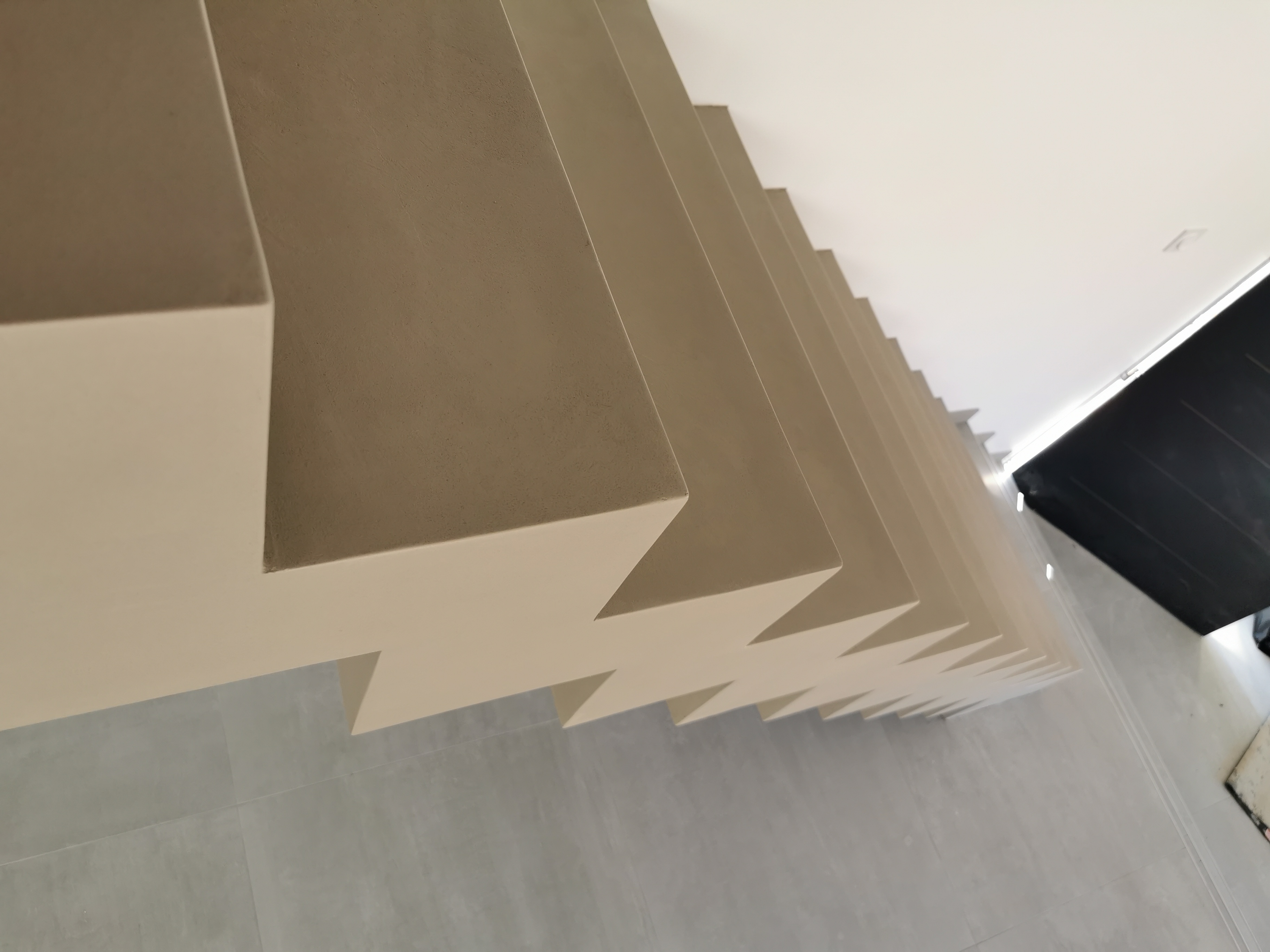 sublime escalier crémaillère dans une pièce à vivre en béton ciré vernis mat couleur galet original À arcachon proche Bordeaux pour un architecte
