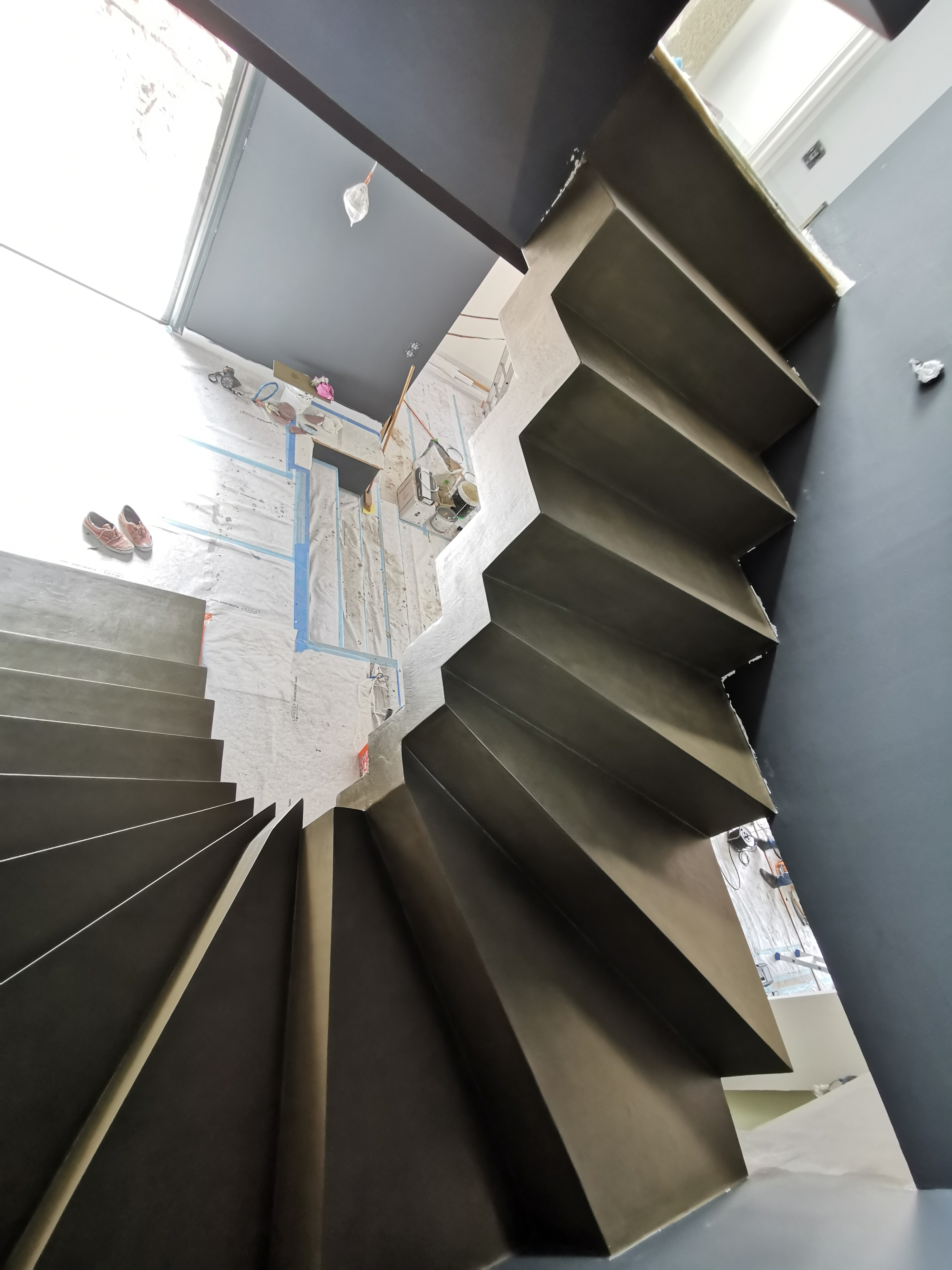 audacieux escalier crémaillère deux quart tournant en béton ciré vernis mat couleur gibraltar Au Pyla-Sur-Mer en Aquitaine dans le sud ouest de la France. pour un maitre d'œuvre