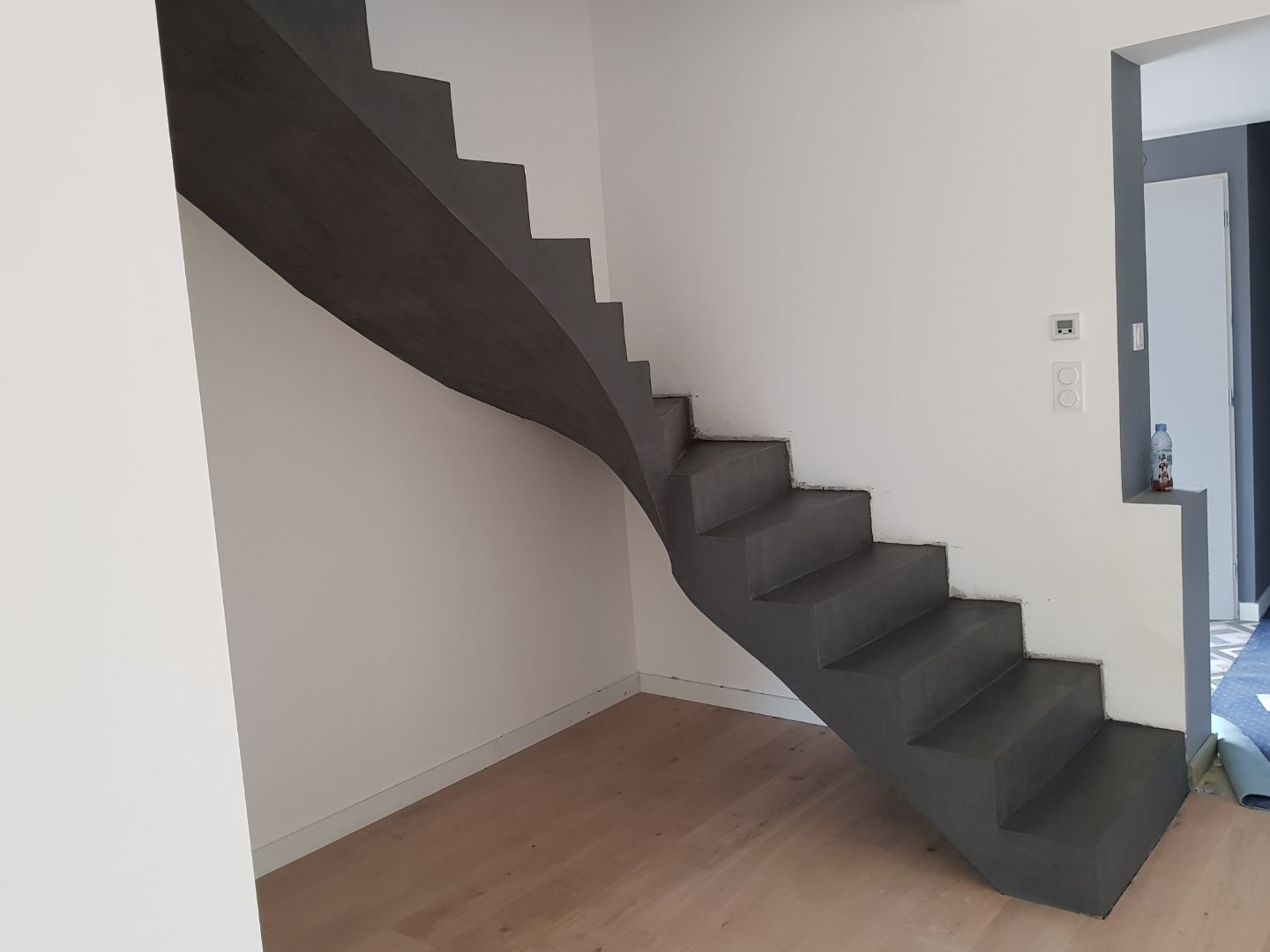 bel escalier à paillasse un quart tournant en béton ciré vernis mat couleur platinium à Escalquens à côté de Toulouse dans le département de la Haute Garonne. pour un particulier