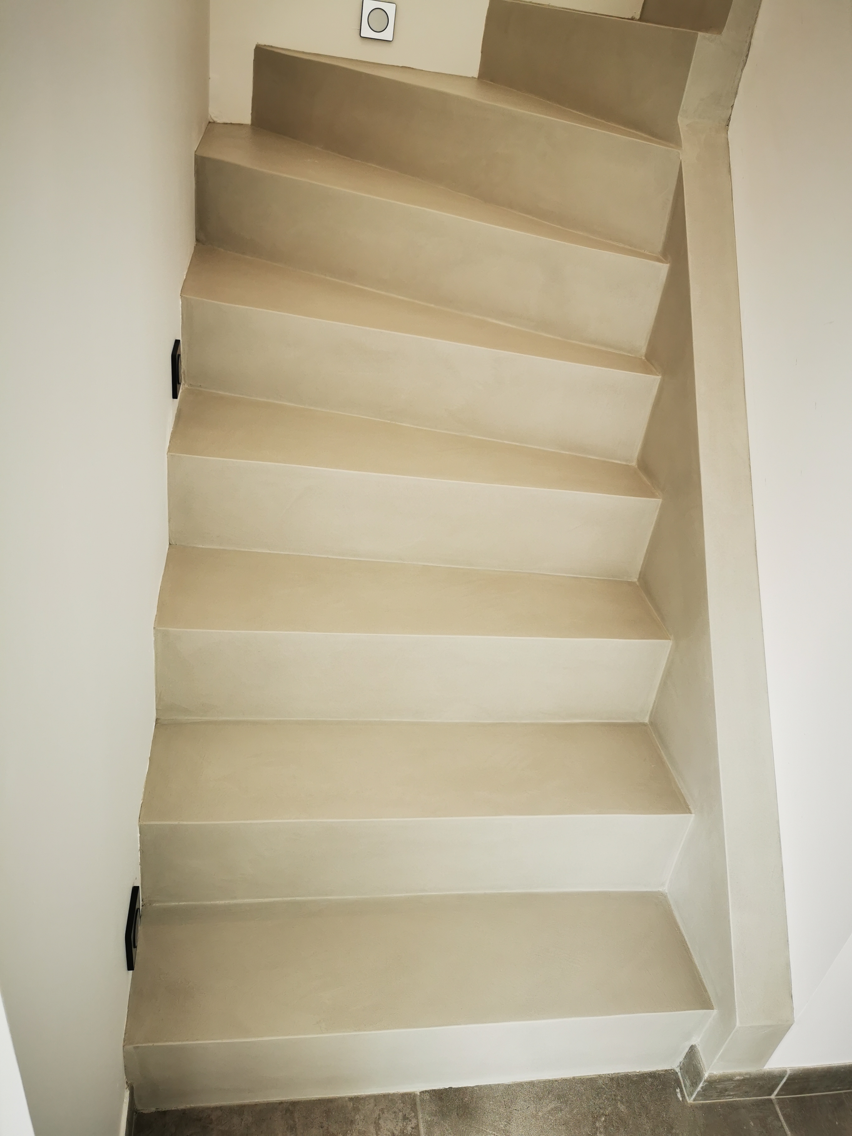 décoration marches d'un escalier à paillasse en béton ciré vernis mat couleur poivre blanc A Saint-Médard proche de Bordeaux en Aquitaine pour un constructeur