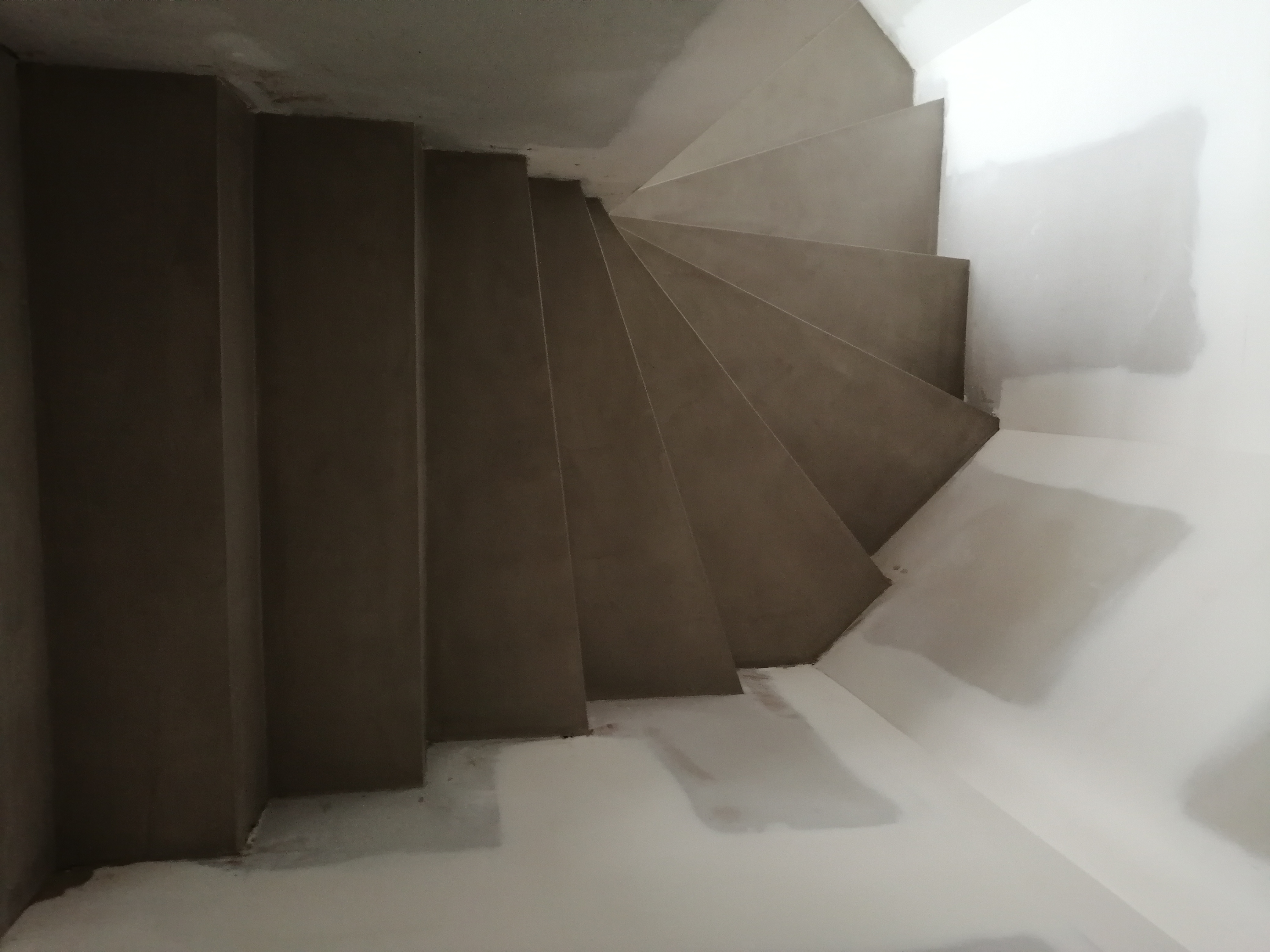 elégant escalier à paillasse deux quart tournant en béton ciré vernis soyeux couleur galet original à Clapier dans le département de l herault. pour un architecte