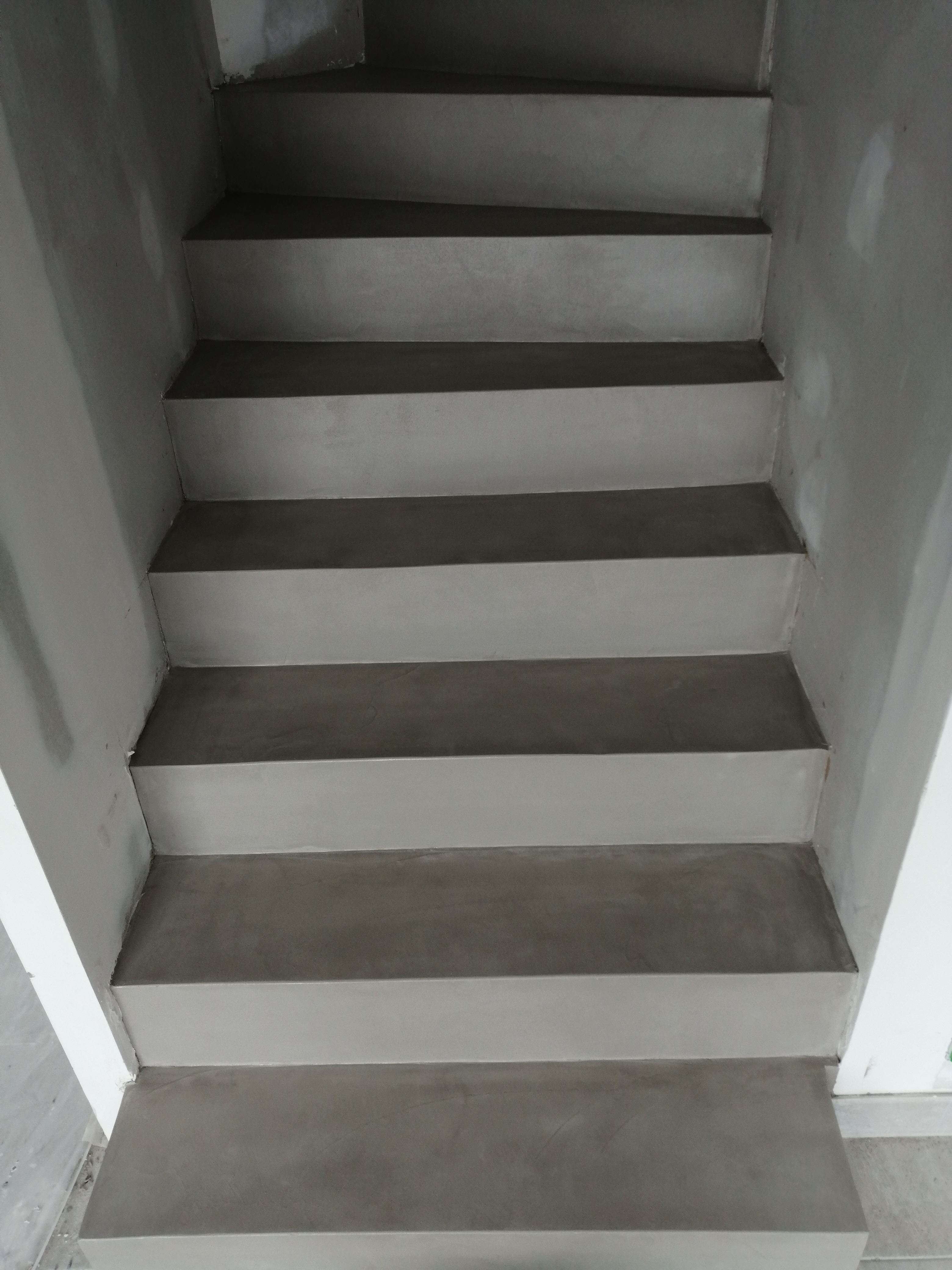 elégant escalier à paillasse deux quart tournant en béton ciré vernis soyeux couleur galet original à Clapier dans le département de l herault. pour un architecte