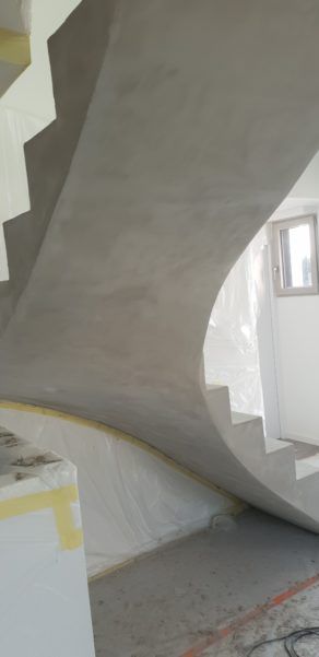 Application d'un béton ciré avec un vernis mat sur la sous face de la paillasse d'un escalier béton