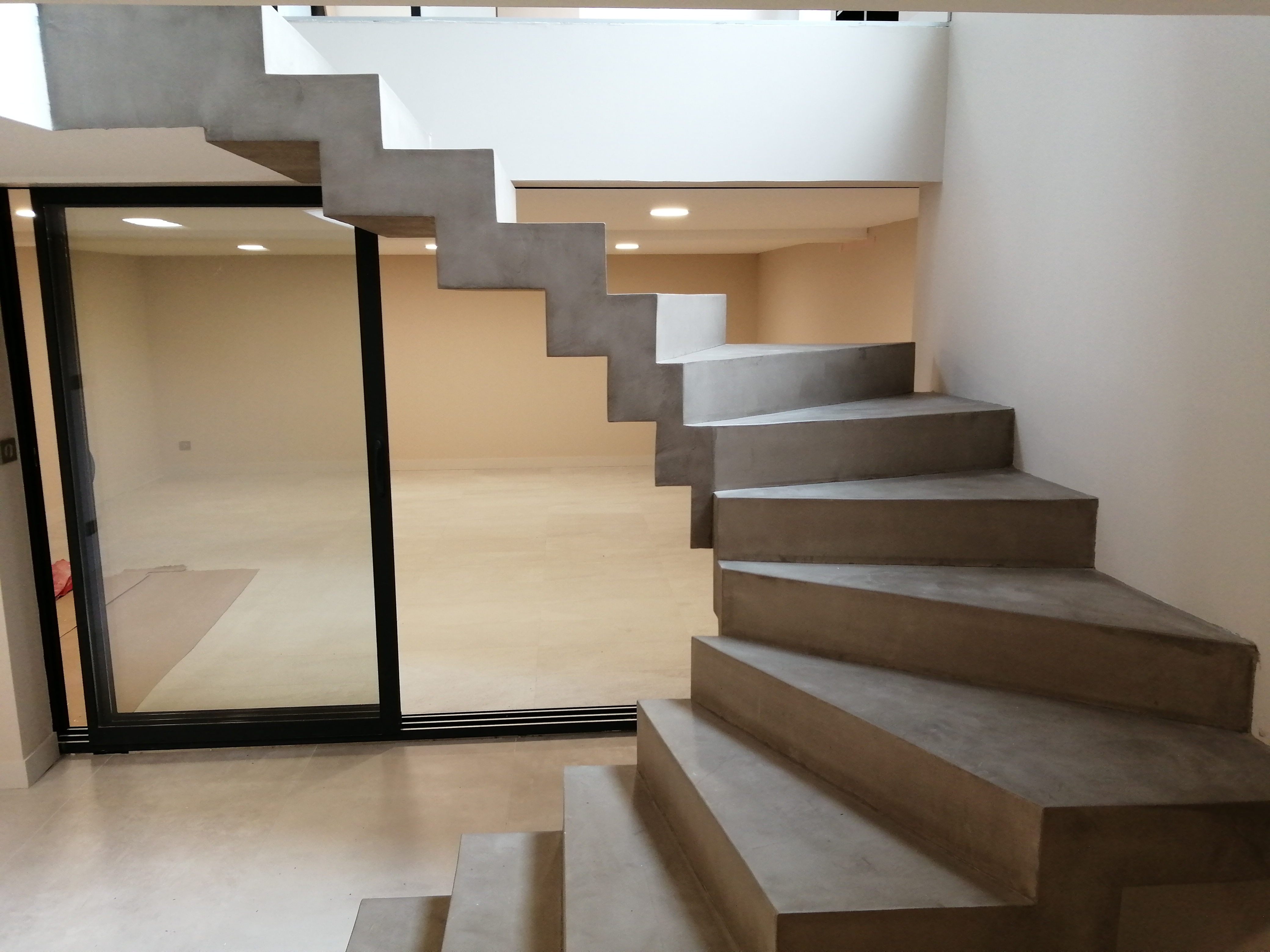 Option béton ciré pour l'habillage de cet escalier tendance avec un choix de couleur judicieusement choisi pour se marier parfaitement avec la peinture et la décoration de la maison