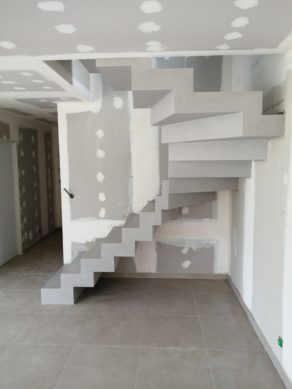 Application d'un béton ciré couleur fossile sur un escalier