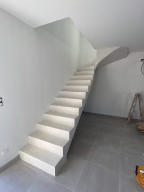 Belle montée d'un escalier à paillasse le long d'un mur dans une maison individuelle à Villeneuve-lès-Avignon près d'Avignon. L'escalier Scal'in est en béton ciré finition vernis mat velouté.