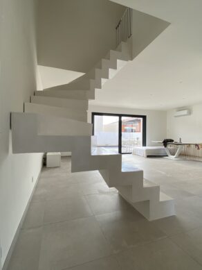 Crémaillère en béton ciré, teinte craie, dans une maison individuelle à Vendargues entre Clapiers et Valergues. Enduit durable et résistant.