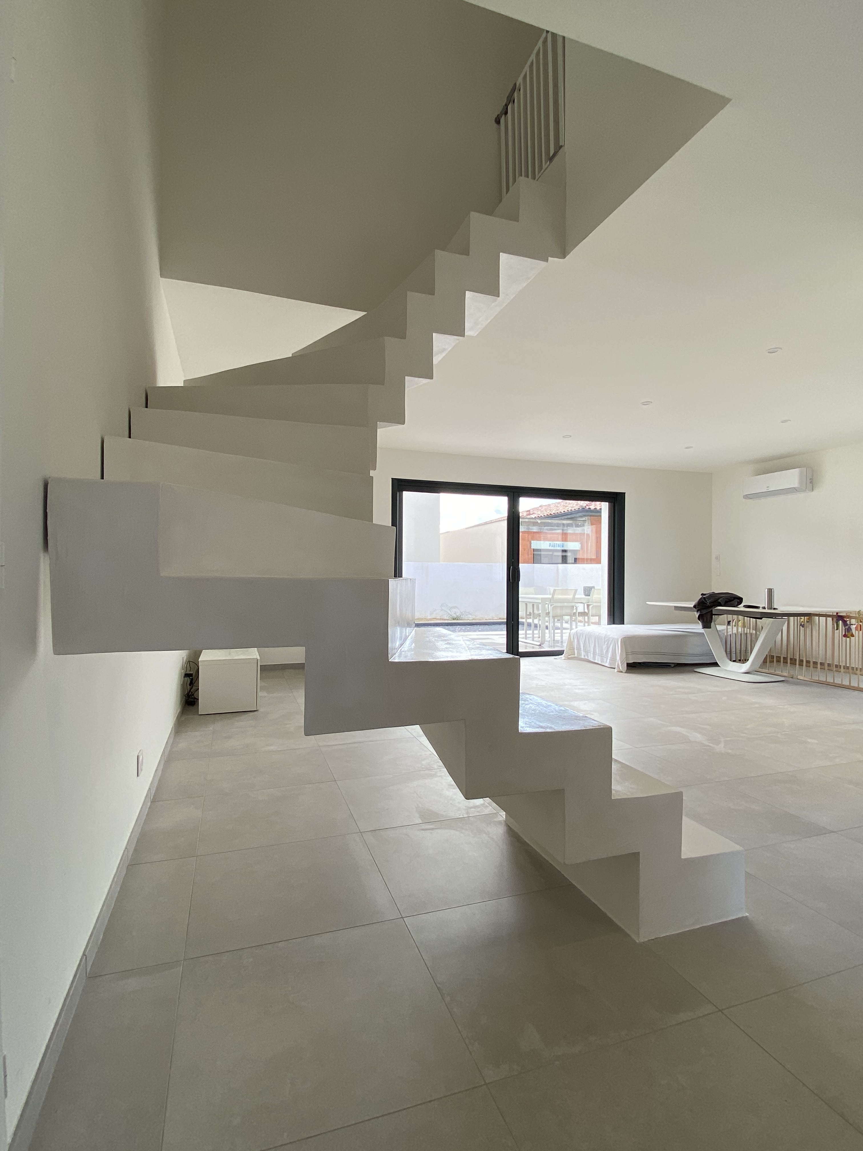 Crémaillère en béton ciré, teinte craie, dans une maison individuelle à Vendargues entre Clapiers et Valergues. Enduit durable et résistant.