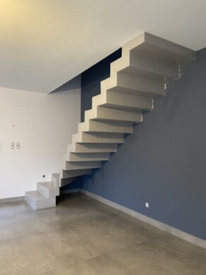 Escalier à crémaillère un quart tournant, en béton ciré vernis mat réalisé dans le département de l'Hérault. Son style à la fois brut et élégant en fait un revêtement particulièrement en vogue.