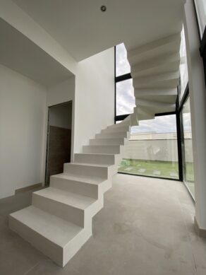 Crémaillère un quart tournant en béton ciré, finition vernis mat velouté. Escalier situé en région Occitanie. Aspect moderne et esthétique.