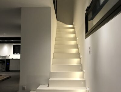 Bel escalier un quart tournant en béton ciré, teinte craie, finition vernis mat velouté, dans une habitation près de Seignosse et Tosse.