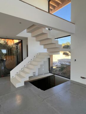 Béton ciré appliqué sur un escalier avec un palier intermédiaire, dans un logement pratiquement terminé.